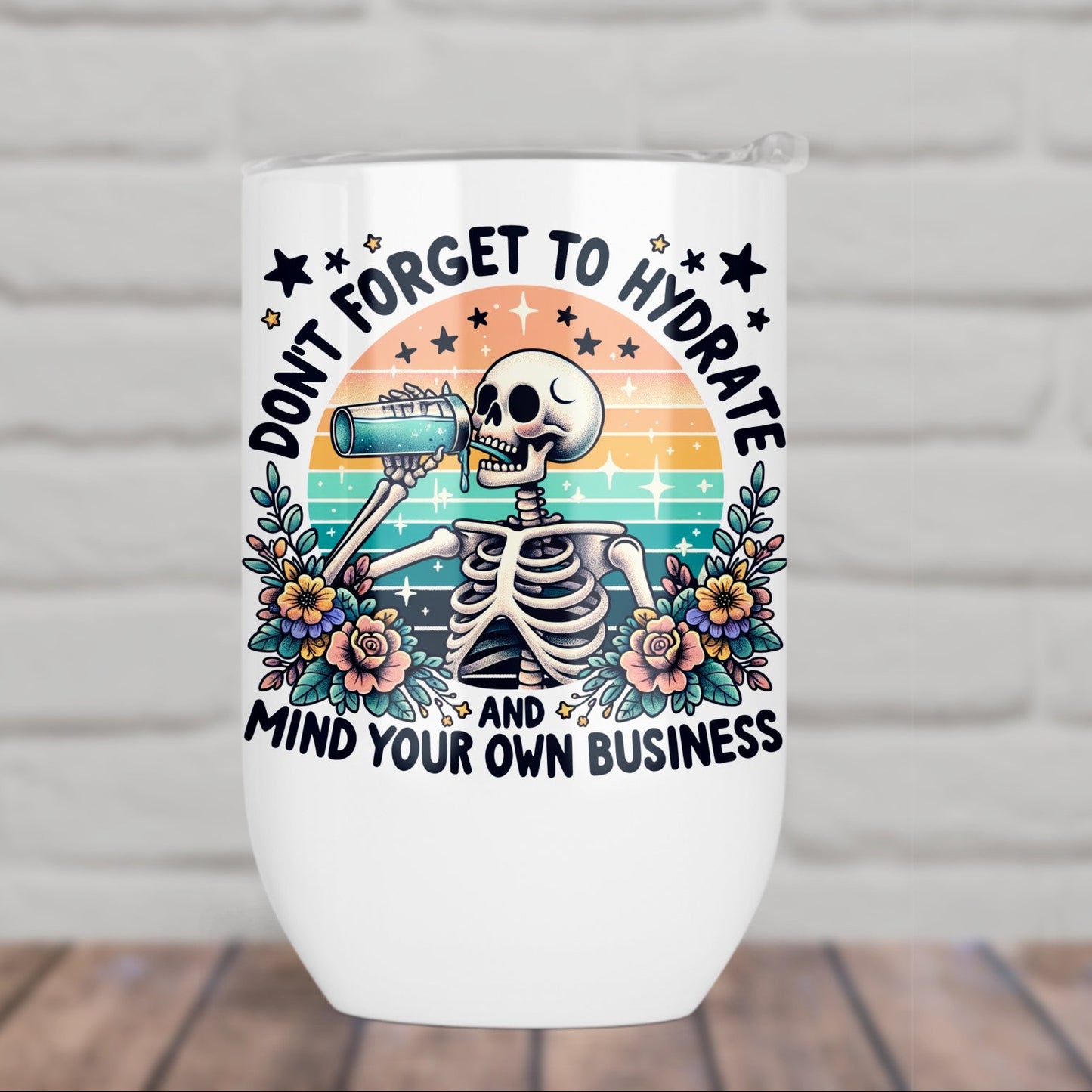 White wine tumbler with a skeleton design and text on a white brick background