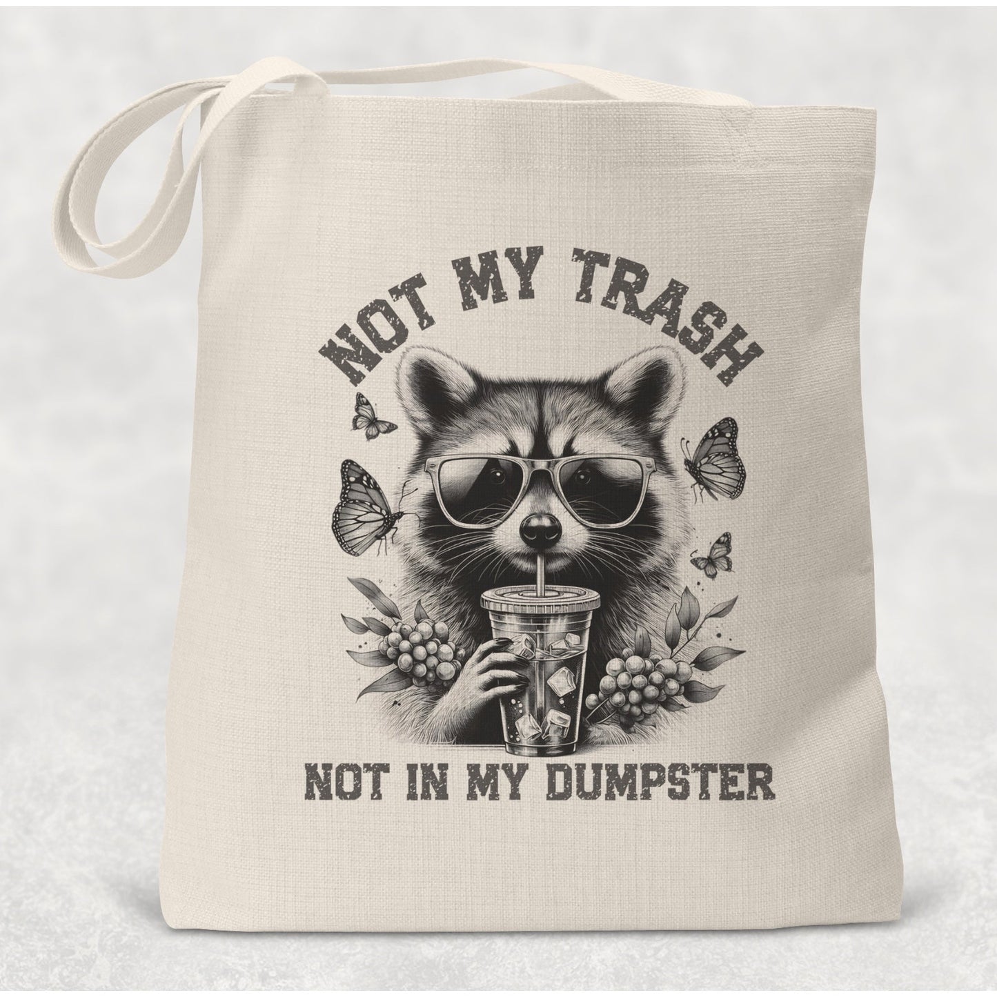 Tote bag with raccoon graphic and text 'Not my trash, not in my dumpster' on a light background