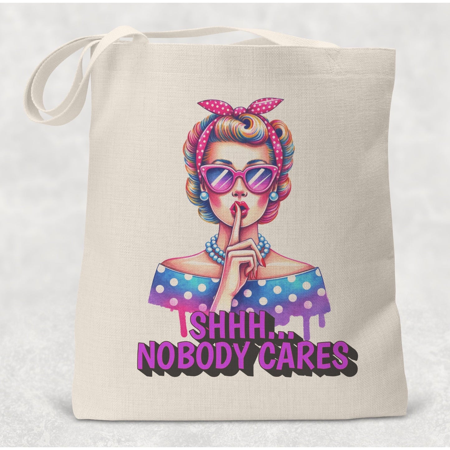 Tote bag with a colorful graphic of a woman and text 'Ishhh... Nobody Cares' on a white background